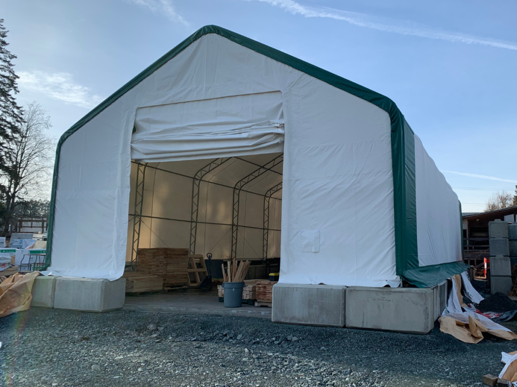 Heavy-duty 30' wide dual-truss fabric structure with a green trim, ideal for mechanic workshops, storage, and industrial use.